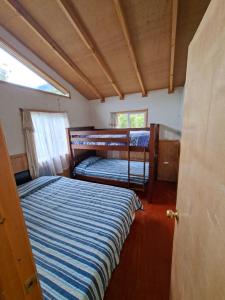 a bedroom with two bunk beds in a house at Cabaña Hornohuinco in Llanquihue