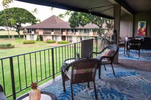 a balcony with chairs and a table and a resort at Maui Eldorado H202 in Kaanapali