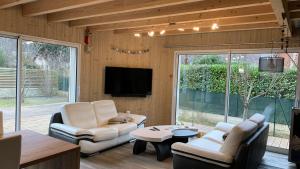 a living room with white furniture and a tv at Villa CASA COSY - Moderne - Climatisation - 3 chambres - 3 salles de bain in Saint-Mamet