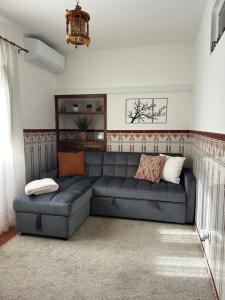 a living room with a blue couch in a room at Refúgio da Azinheira in Torrão