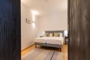 a bedroom with a bed with white sheets and pillows at Villa Nestor in Ingenio +90 photos