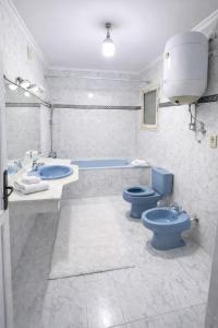 a bathroom with two blue toilets and a tub at 3 Pyramids Grand Egyptian Museum View in Cairo