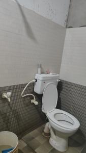 a bathroom with a white toilet in a stall at Maa Tarini AC Dormitory in Balasore