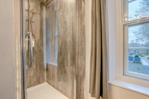 a shower with a glass door next to a window at 4 Bed in Brecon oc-h30823 in Brecon +20 photos