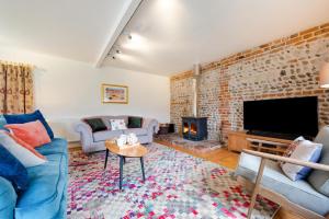 a living room with a brick wall and a fireplace at 3 Bed in Ridlington oc-2253 in Walcott