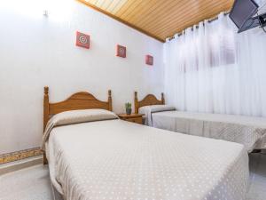 a bedroom with two beds and a tv on the wall at Apartment Delfines by Interhome in Cambrils