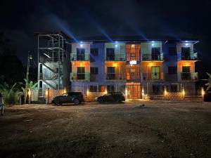 two cars parked in front of a building at night at Studio Residence OR Tambo in Kribi