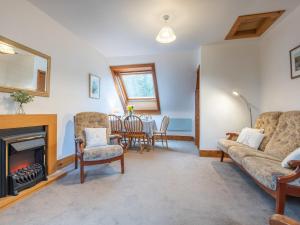 a living room with a fireplace and a table and chairs at Apartment Pond View on Aigas Golf Course by Interhome in Beauly