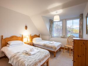 a bedroom with two beds and a window at Apartment Pond View on Aigas Golf Course by Interhome in Beauly