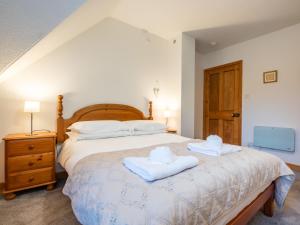 a bedroom with a bed with two towels on it at Apartment Pond View on Aigas Golf Course by Interhome in Beauly +24 photos