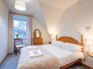 a bedroom with a large bed and a window at Apartment Pond View on Aigas Golf Course by Interhome in Beauly