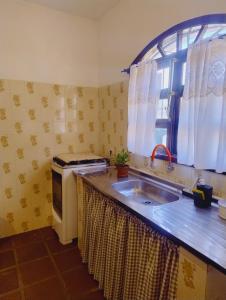 a kitchen with a sink and a window at Quinta essência suites e chalés in Ubatuba +85 photos