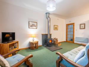 a living room with a fireplace and a couch at Apartment Old Stable on Aigas Golf Course by Interhome in Beauly