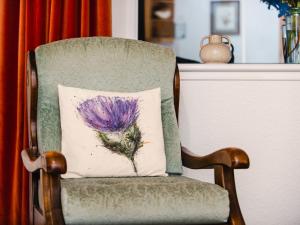 a pillow on a chair with a purple flower on it at Apartment Old Stable on Aigas Golf Course by Interhome in Beauly +17 photos