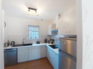 a kitchen with white cabinets and blue appliances at Holiday Home Bretons by Interhome in Capbreton