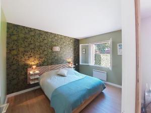 a bedroom with a bed with a green wall at Holiday Home Bretons by Interhome in Capbreton