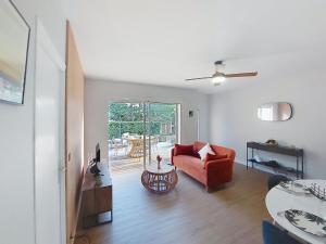 a living room with a red chair and a table at Holiday Home Bretons by Interhome in Capbreton