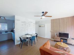 a living room with a table and chairs and a couch at Holiday Home Bretons by Interhome in Capbreton +22 photos