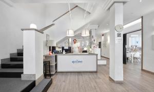 a man standing behind a counter in a building at Hotel Arlecchino Riccione in Riccione