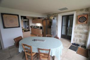 a kitchen with a table with chairs and a refrigerator at Casa Una Storia in Sartène