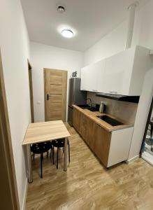 a kitchen with a wooden table and a counter top at Apartamenty na Witosa in Nowa Sól
