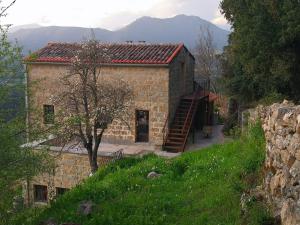 a large stone building with a staircase in front of it at Casa Una Storia in Sartène
