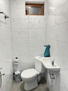 a white bathroom with a toilet and a sink at Бунгала ЛАГО in Gabrene +17 photos