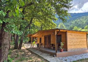 a small wooden cabin in the woods with trees at Бунгала ЛАГО in Gabrene