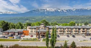 a hotel with a parking lot and mountains in the background at Prestige Golden Hotel in Golden
