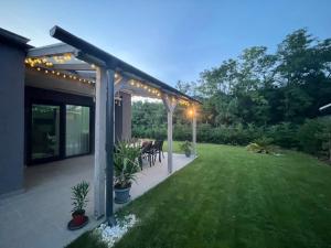 a backyard with a pergola with a table and chairs at Sissy Ring House in Mogyoród