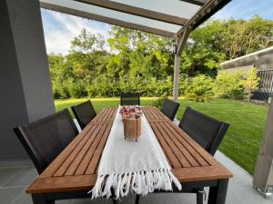 a wooden table with chairs on a patio at Sissy Ring House in Mogyoród +2 photos