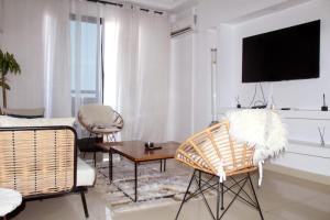 a living room with a tv and a table and chairs at AZURA Skyline in Abidjan