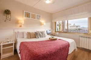 a bedroom with a bed with a red blanket and a window at Terraza con encanto Parking Piscina Portaventura in Salou +41 photos