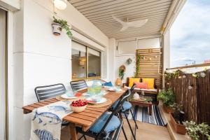 a wooden table and chairs on a patio at Terraza con encanto Parking Piscina Portaventura in Salou