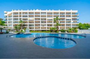 a large building with a swimming pool in front of a building at Terraza con encanto Parking Piscina Portaventura in Salou