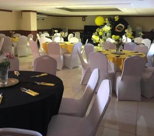 a banquet hall with white tables and white chairs at Hotel La Esperanza in Chitré