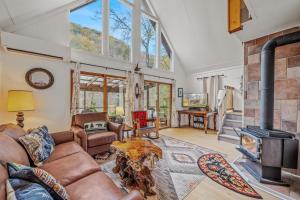 a living room with a couch and a fireplace at River Time Cabin - Riverfront, Hot Tub, Screen Porch, Fishing, Games, View, 3 King Beds in Berkeley Springs