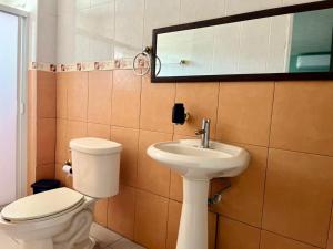 a bathroom with a toilet and a sink and a mirror at 1 VENATOR House Boutique in León +9 photos