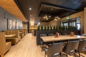 a dining room with tables and chairs and plants at Prestige Golden Hotel in Golden