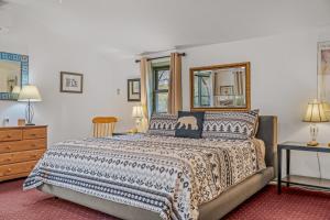 a bedroom with a bed and a dresser and a mirror at River Time Cabin - Riverfront, Hot Tub, Screen Porch, Fishing, Games, View, 3 King Beds in Berkeley Springs