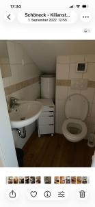 a bathroom with a toilet and a sink at Monteurszimmer Schöneck in Schoneck