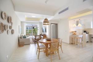 a dining room and living room with a table and chairs at Destination Jelly Playa Coral Condo in Punta Cana