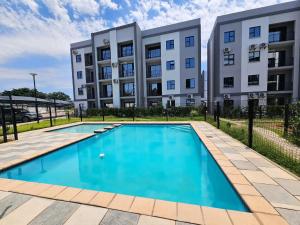 a swimming pool in front of a building at Moonlight Apartment in Gaborone