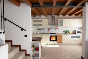 a kitchen with white cabinets and a staircase at A casa di Giò in Vittorio Veneto