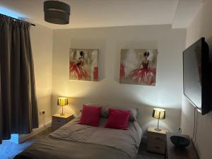 a bedroom with a bed and two paintings on the wall at Flat in Pont y Rhyl in Pont y Cymmer