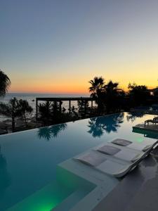 a swimming pool with a view of the ocean at sunset at Ilyonis Residence apartment luxury in Shëngjin
