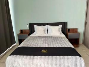 a bed with a black and white comforter and pillows at 2 VENATOR House Boutique in León