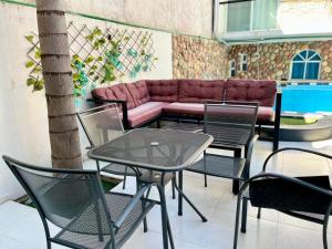 a patio with a table and chairs and a couch at 2 VENATOR House Boutique in León