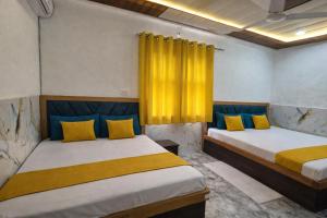 two beds in a room with yellow and blue at H0TEL PARBU KIRPAA Near Premanand Ji Maharaj Mandir Vrindavan in Chhatikara