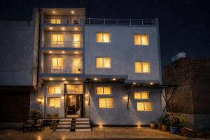 a large white building with lit windows at night at H0TEL PARBU KIRPAA Near Premanand Ji Maharaj Mandir Vrindavan in Chhatikara